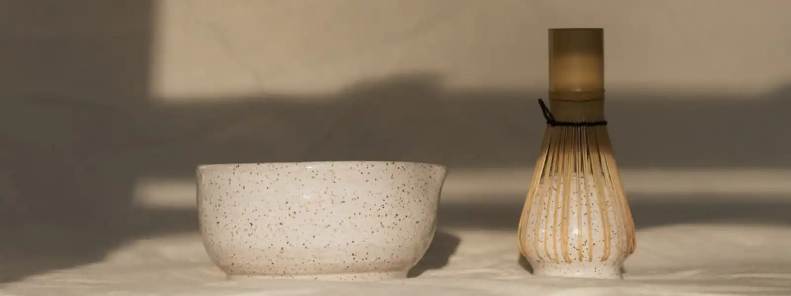 Traditional bamboo matcha whisk (chasen) and ceramic tea bowl for Japanese tea ceremony.